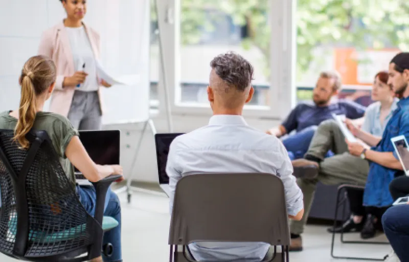 Des personnes participent à un cours collectif sur l'argent et les dettes.